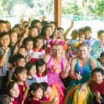 A group of children posing for a photo with a fairy.