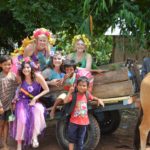 A group of people posing with a cow.