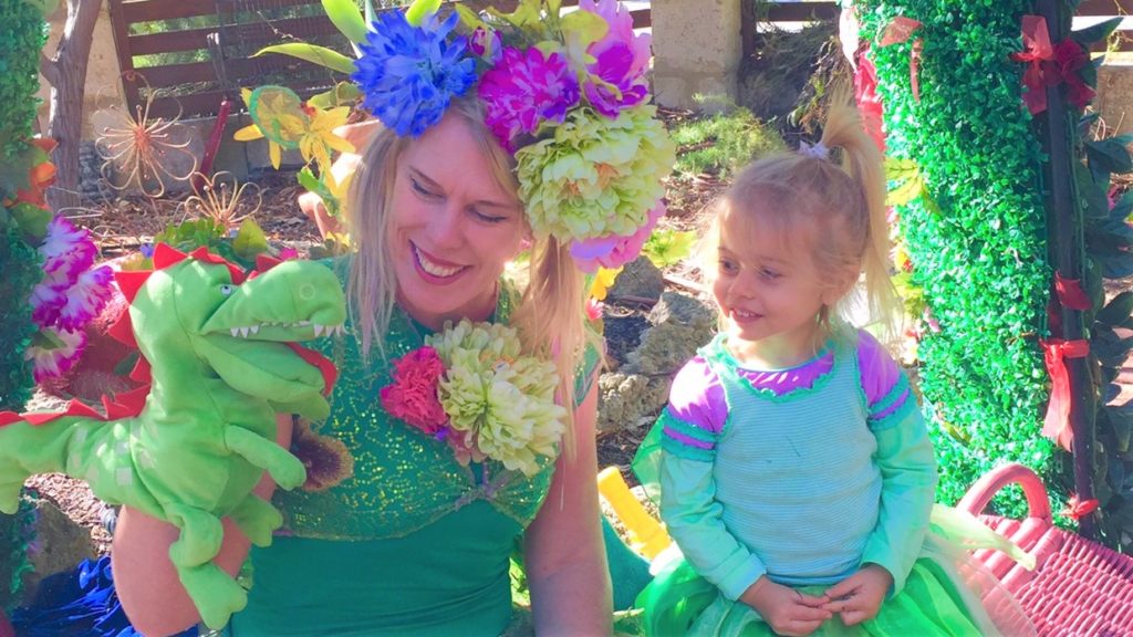 A woman and a girl wearing green and purple clothing.