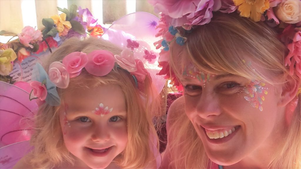 A woman and a child with flowers on their head.