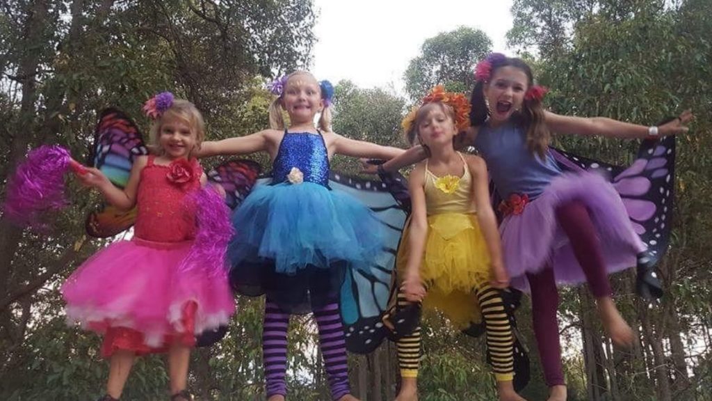 A group of girls in colorful tutus posing for a photo.