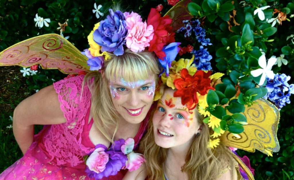 Two women wearing fairy clothing and flowers.