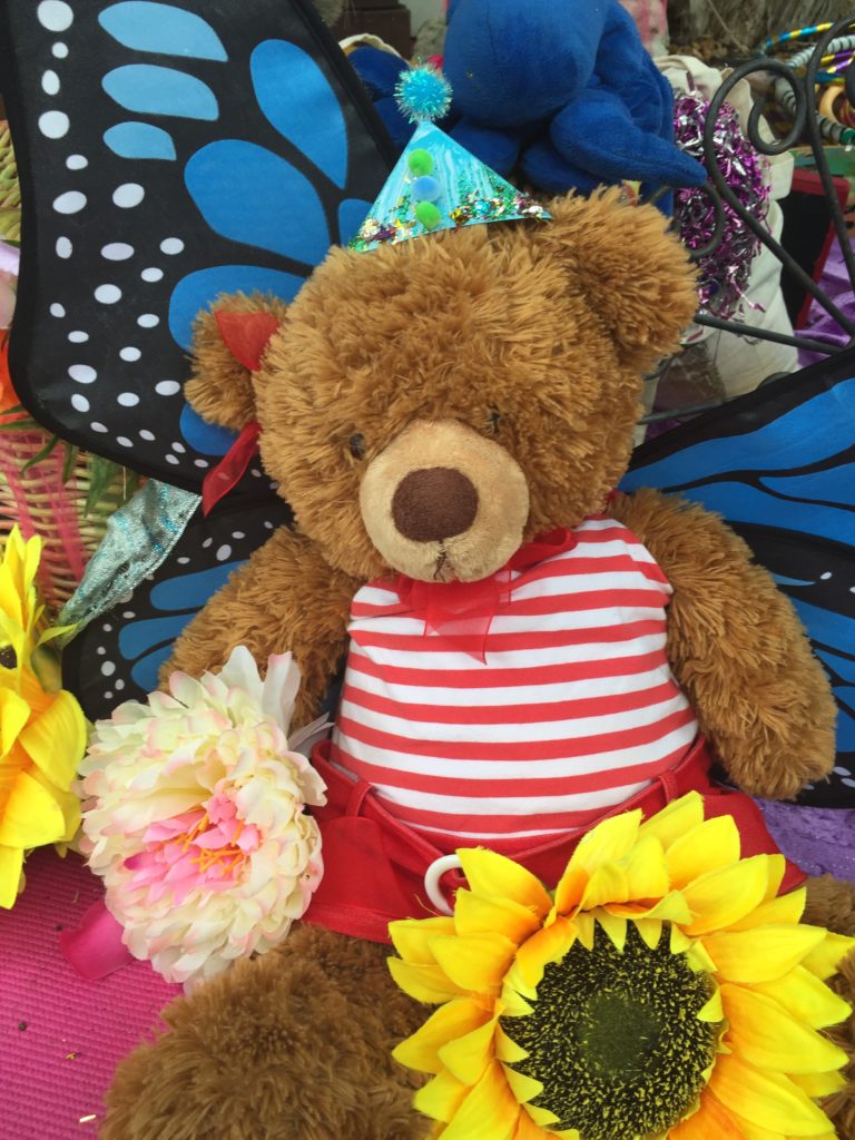 A teddy bear with a hat and flowers.