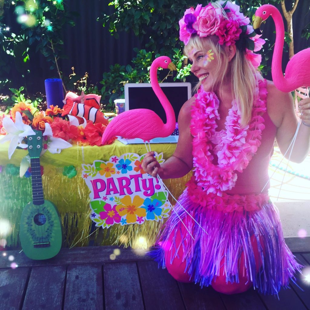 A woman wearing a garment and holding flamingos.