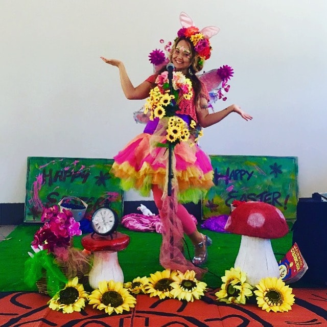 A girl dressed up as a fairy performs on stage.