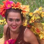 A woman wearing a garment with flowers on her head.