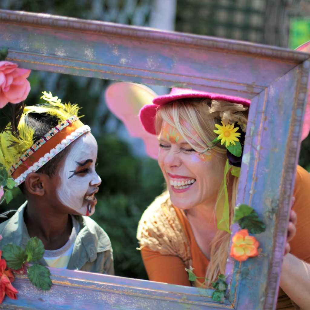 A woman holding a frame with a child in it.