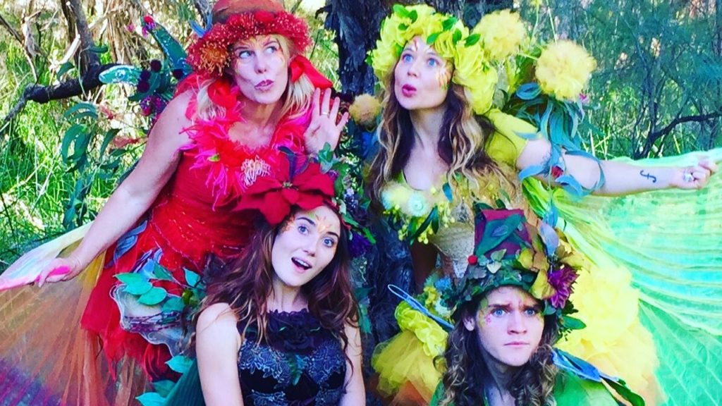 A group of women dressed in fairy costumes are posing for a photo.