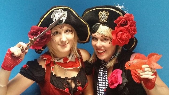 Two women in pirate costumes posing for a photo.