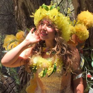 A woman in a yellow costume is posing for a picture.