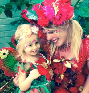 A woman dressed as a fairy with a little girl.