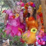 Two women dressed up as flower fairies in the woods.