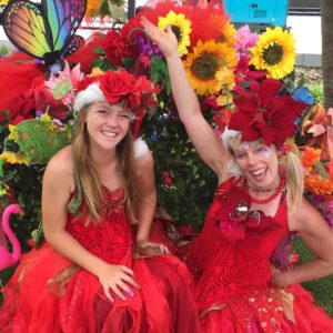 Two women in red dresses and flowers.