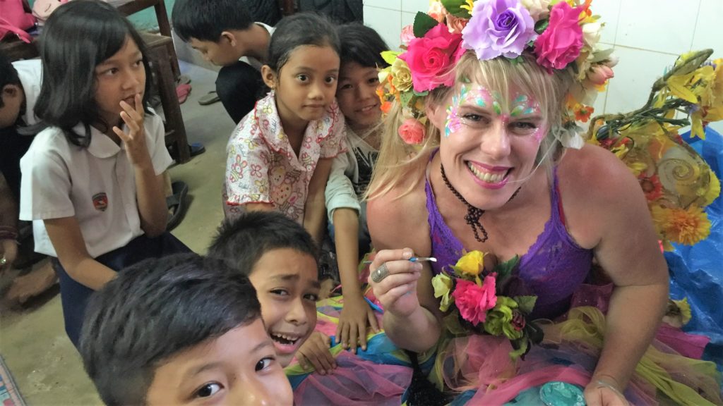 A woman dressed as a fairy with children around her.