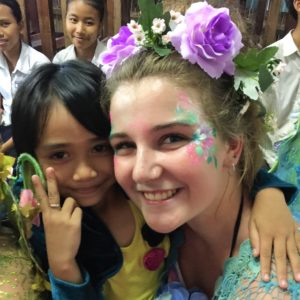 A girl with flowers on her face is posing for a picture.