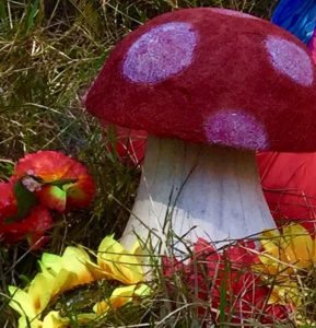 A mushroom with a red hat and a red flower.