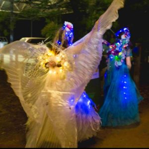 A group of people dressed up in costumes with lights on their heads.