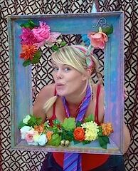 A woman in a frame with flowers.