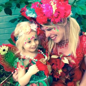 A woman dressed as a fairy with a little girl.