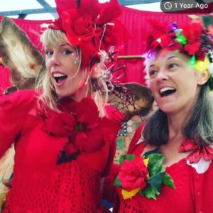 Two women in red costumes posing for a photo.