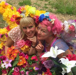 Two women posing with flowers.