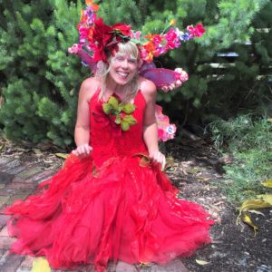 A woman in a red dress sitting on the ground.