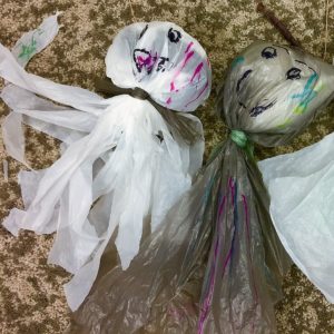 Three ghosts made out of plastic bags.