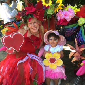 A woman dressed as a fairy with a little girl.