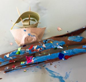 A boat made of sticks and confetti.