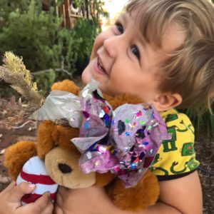 A young boy holding a teddy bear.