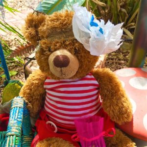 A teddy bear wearing a striped dress.